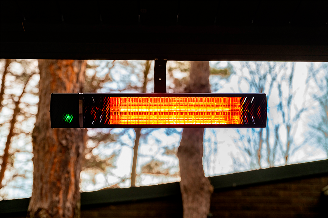Outdoor infrared patio heater mounted under pergola providing warmth for outdoor seating area