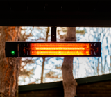 Outdoor infrared patio heater mounted under pergola providing warmth for outdoor seating area