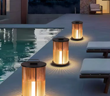 Outdoor lantern lights illuminating modern poolside patio at dusk with lounge seating and mountain view