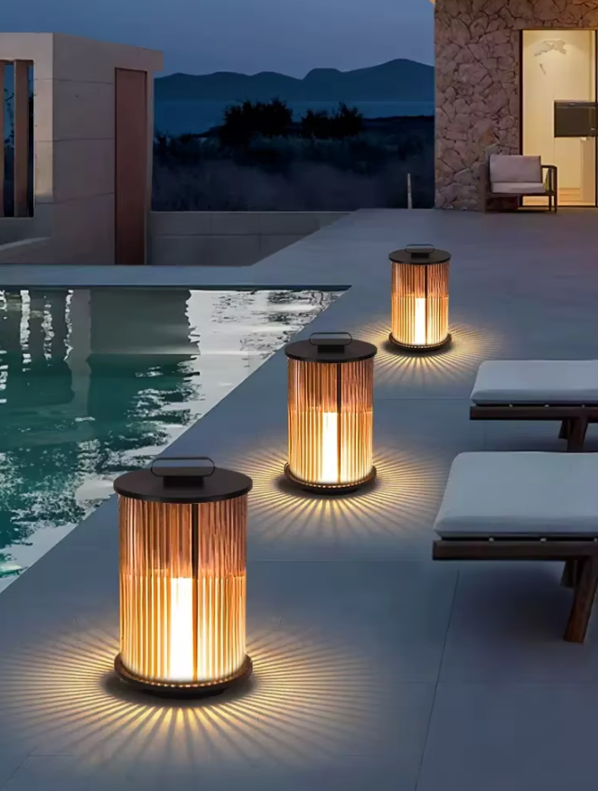 Outdoor lantern lights illuminating modern poolside patio at dusk with lounge seating and mountain view